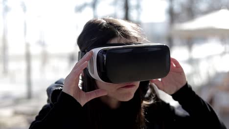Focused-woman-using-VR-headset-on-street
